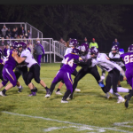 Football players on field in the middle of play with other team