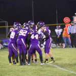 Murray players in huddle on football field