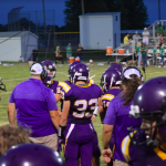 Coach talking to players on sideline