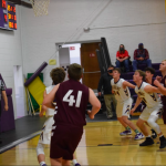 Boys basketball players playing defense under basket