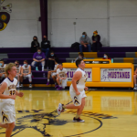 Boys basketball players running down the court