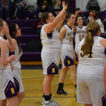 Hannah shooting basketball with team mates around her