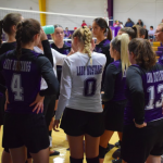 Girls HS volleyball team in a huddle